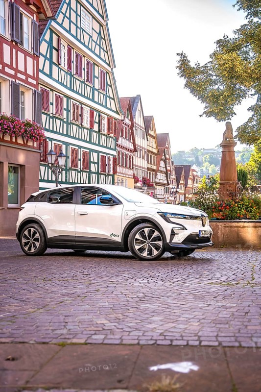 White car in an old town with magnificent half-timbered buildings and a statue, Deer E-Carsharing, Renault Megane, Calw, Germany
