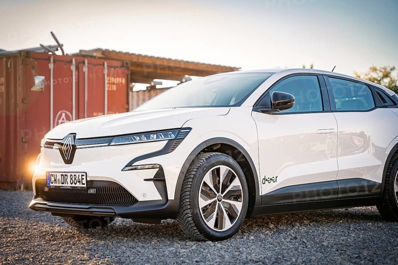 A white electric car stands on a gravel field in front of a container at dusk, Deer E-Carsharing, Renault Megane, Calw, Germany