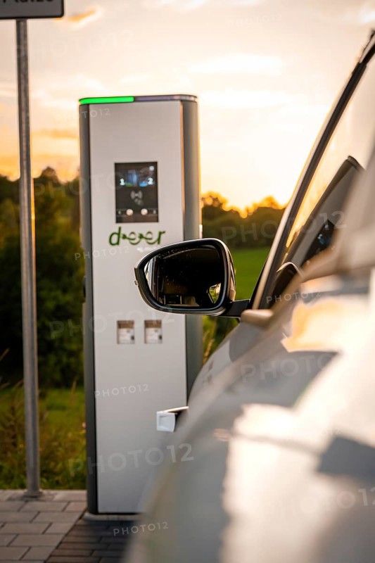 A vehicle is parked at a charging station in a rural area at sunset, Deer E-Carsharing, Renault Megane, Calw, Germany