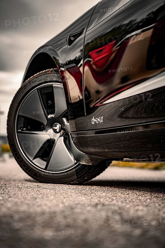 Close-up of a shiny black car with focus on tires, Deer E-Carsharing, Tesla Model 3, Calw, Germany