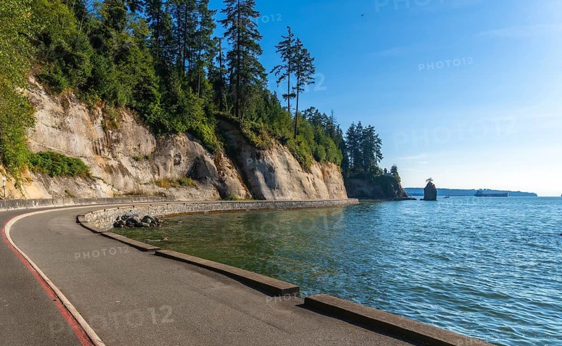 Breathtaking view of the scenic road winding along the coastline in stanley park. Vancouver. British columbia. With siwash rock in the distance. Showcasing the natural beauty of the pacific northwest