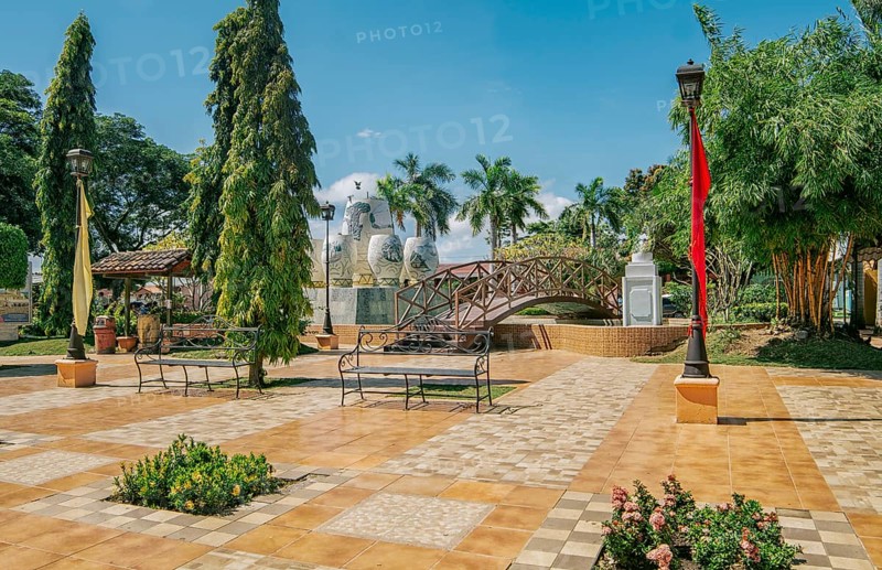 A nice and relaxed park with a wooden bridge over a water fountain, Traditional park of Nagarote, Nicaragua. View of a calm park with a small wooden bridge on a sunny day. Nagarote central park