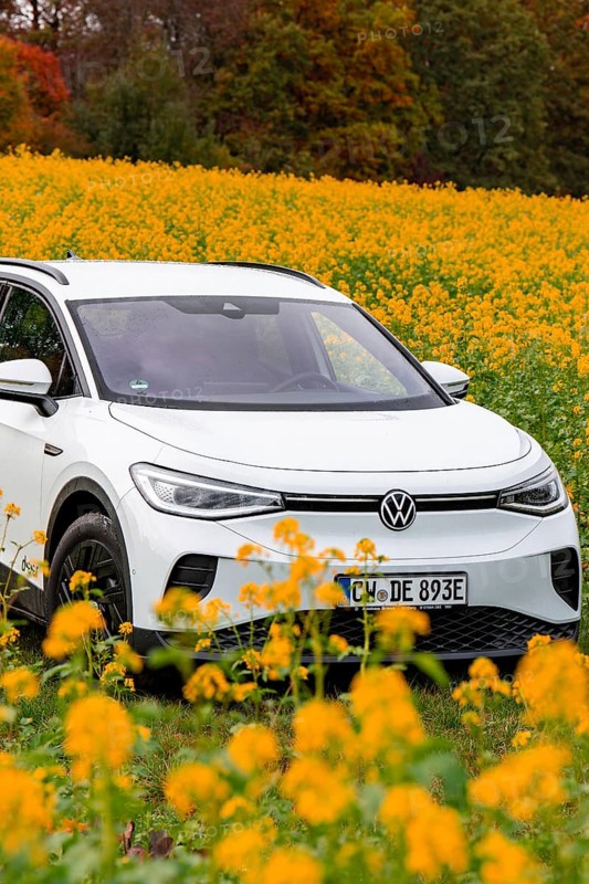 A white car is parked in a yellow flower field under a clear sky, Deer E-Carsharing, VW ID4, Calw, Germany
