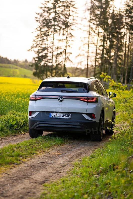SUV traveling on a rural path surrounded by green fields, deer e-car sharing, VW ID4, Calw, Germany