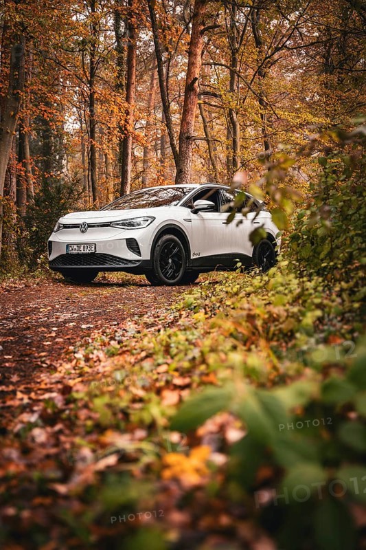 SUV in an autumn-colored forest on a narrow path, Deer E-Carsharing, VW ID4, Calw, Germany