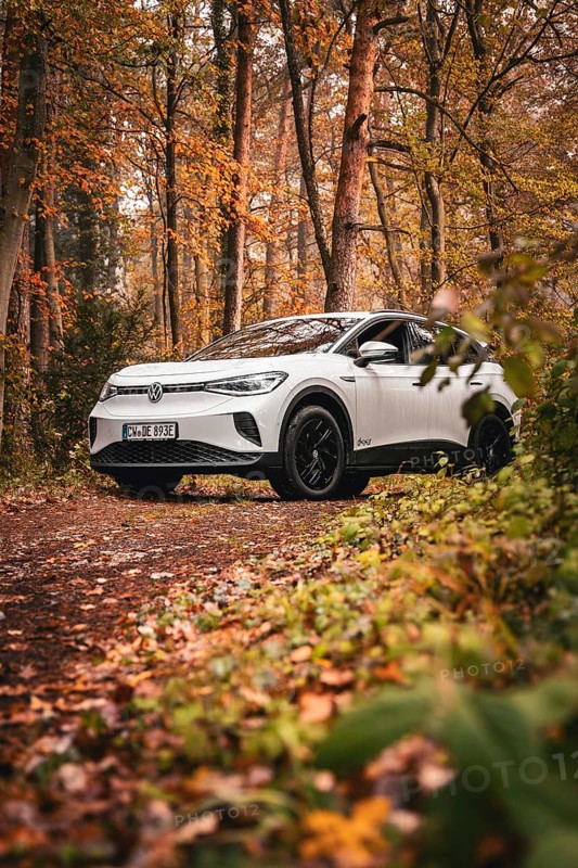 A white SUV on a forest path surrounded by autumn trees and foliage, Deer E-Carsharing, VW ID4, Calw, Germany