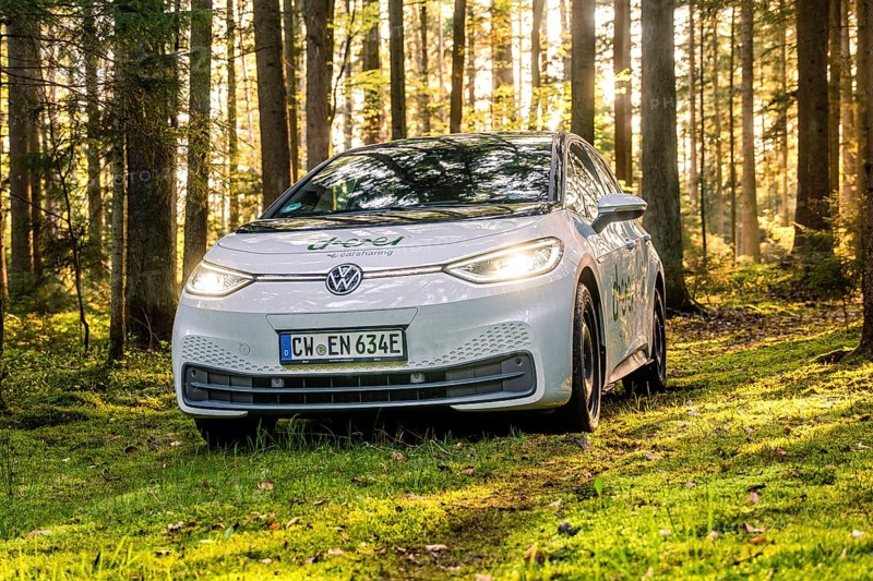 A white car in the forest with sunbeams, license plate CW EN 634E, Deer E-Carsharing, VW ID3, Calw, Germany