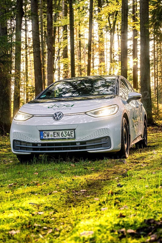 A car on a forest path, illuminated by sunlight, license plate CW EN 634E, Deer E-Carsharing, VW ID3, Calw, Germany