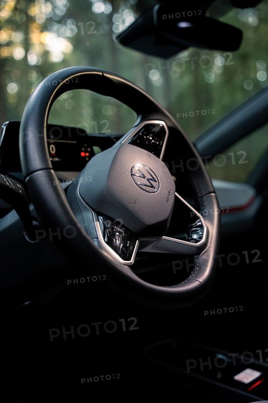 Close-up of a steering wheel in the interior of a car surrounded by a wooded background, Deer E-Carsharing, VW ID3, Calw, Germany