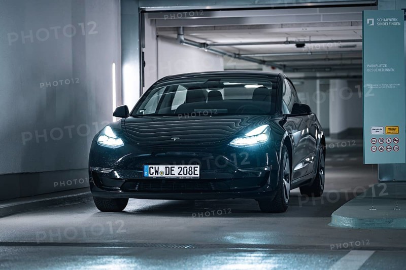 Black car drives into a modern, well-lit garage with cool atmosphere, Deer E-Carsharing, Tesla Model 3, Calw, Germany