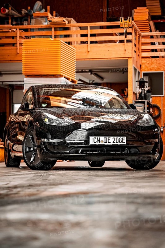 Black Tesla in a workshop environment with industrial flair, Deer e-Carsharing, Tesla Model 3, Calw, Germany