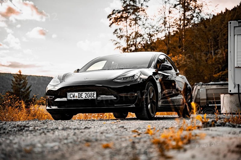Black Tesla on a street at sunset in natural surroundings, Deer e-Carsharing, Tesla Model 3, Calw, Germany