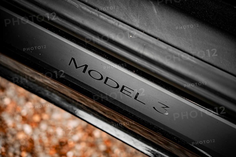 Close-up of a black car with model 3 emblem on a metallic surface, Deer E- car sharing, Tesla Model 3, Calw, Germany