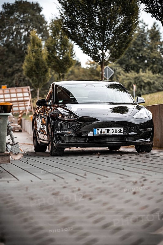 Black car from the front with surroundings and trees in the background, Deer e-Carsharing, Tesla Model 3, Calw, Germany