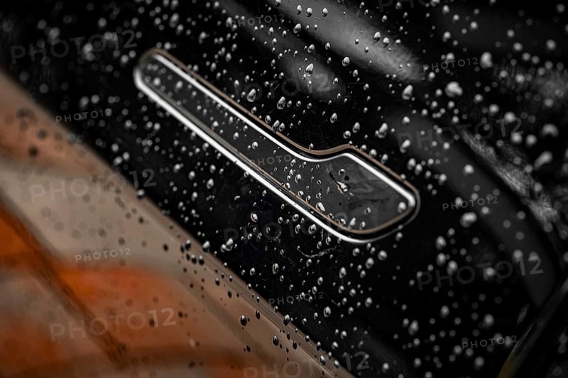 Close-up of a black car with water droplets on the surface showing shiny details, Deer E- car sharing, Tesla Model 3, Calw, Germany