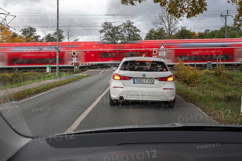 Regional train crosses a restricted level crossing, cars waiting in front of it, Fürth Mittelfranken, Bavaria, Germany