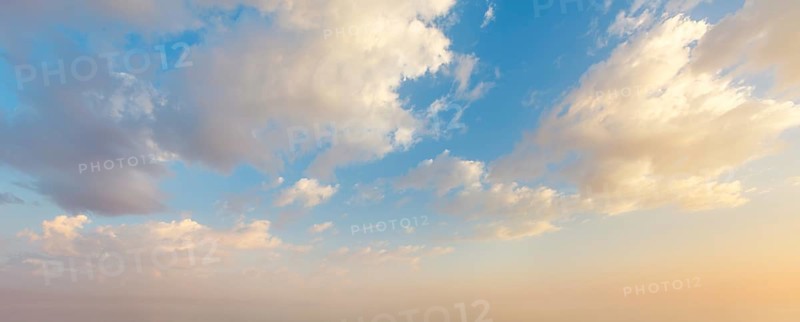 Colorful sunset sky showcases vibrant hues and fluffy clouds as day transitions into night, creating a beautiful and serene scene