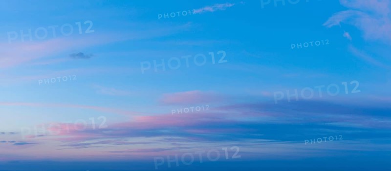 A beautiful twilight sky showcases vivid pink and blue colors as the sun sets, creating a serene and dramatic atmosphere in the evening
