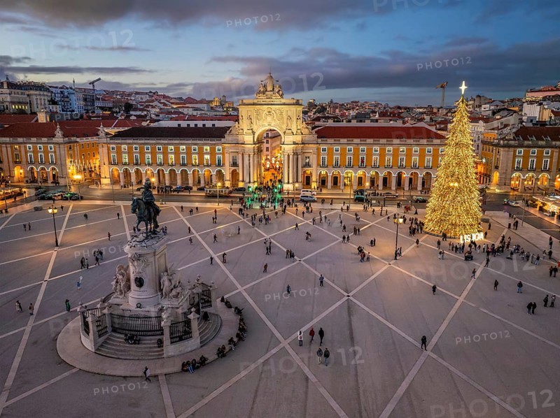 Praca do Comercio glows in the evening with a decorated Christmas tree and festive lights, creating a magical winter atmosphere. Lisbon, Portugal