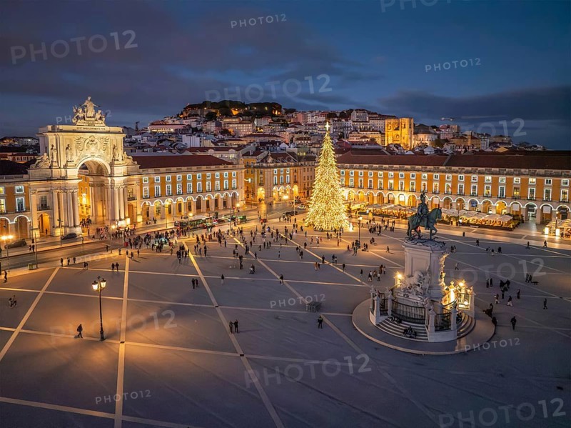 Praca do Comercio in Lisbon lights up with an impressive Christmas tree and festive decorations during the winter evening twilight
