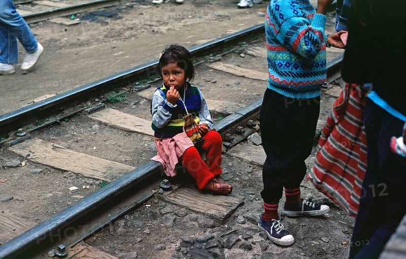 Little girl sitting on railroad tracks, Agua Caliente, Andean Highlands, Peru, South America, September 1997, vintage, retro, old, historic