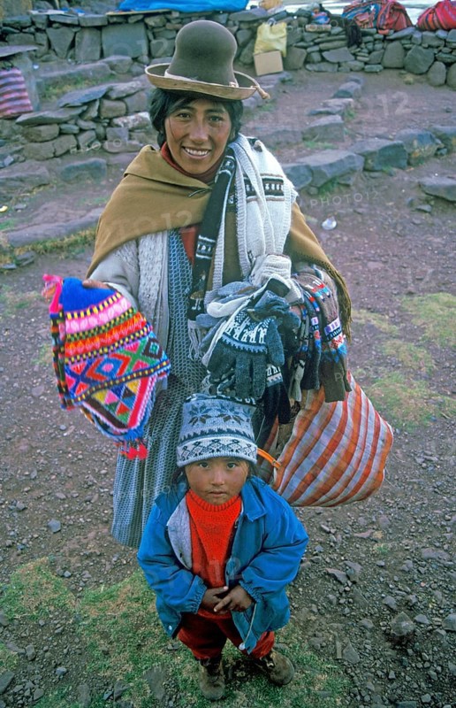 A woman with a small child sells souvenirs to tourists at the Sillustani ruins on Lake Umayo near Puno, Andean highlands, Peru, South America, September 1997, vintage, retro, old, historic