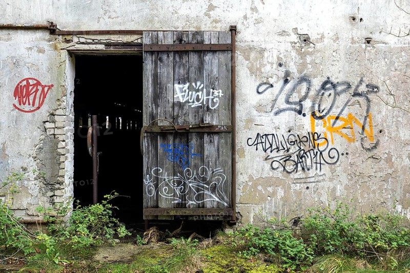 Wall with Grafity and Gate, dilapidated complex of a former agricultural production cooperative of the former GDR, LPG, Lost Place, Müggenburg, Fischland-Darß-Zingst, Western Pomerania National Park, Mecklenburg-Western Pomerania, Germany