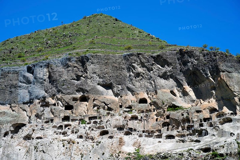 A steep mountain with numerous caves under a clear blue sky, cave town, cave monastery, Vardzia, Samtskhe—Javakheti region, Samtske Javacheti, Lesser Caucasus, Georgia