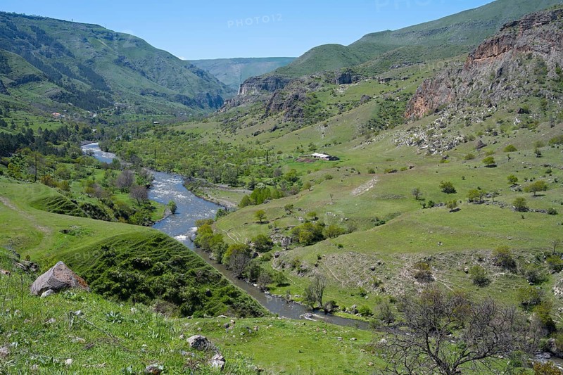 A panoramic view of a green valley with a river surrounded by rolling hills, Kura river, landscape near Vardzia, Samtskhe—Javakheti region, Samtske Javacheti, Lesser Caucasus, Georgia