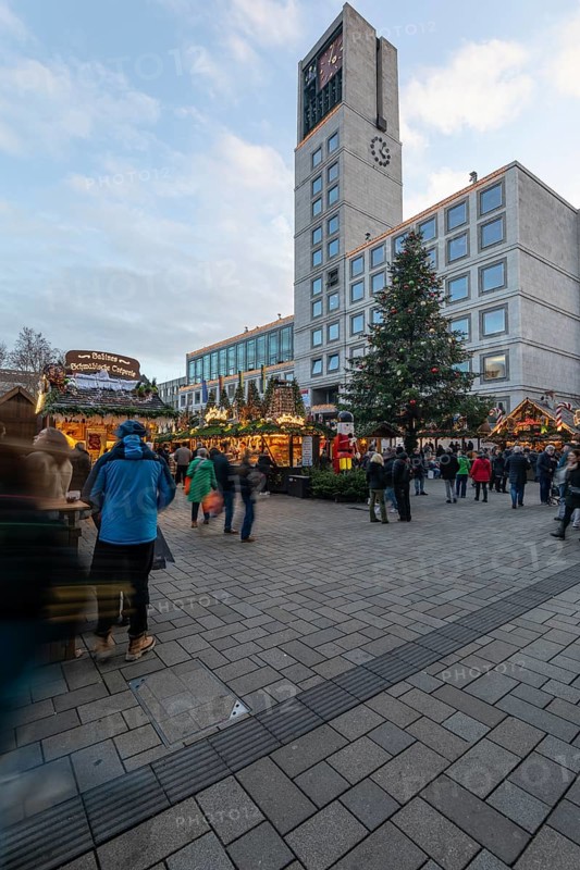 The Christmas market on the market square, in front of Stuttgart City Hall 2025, shines in festive lights in the evening. Many people visit the stands and enjoy the Christmas atmosphere