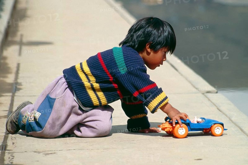 Little boy playing with toy car, Puno, Andean Highlands, Peru, South America, September 1997, vintage, retro, old, historic