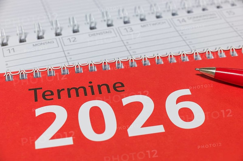 Red 2026 calendar with spiral binding and a red pen, diary