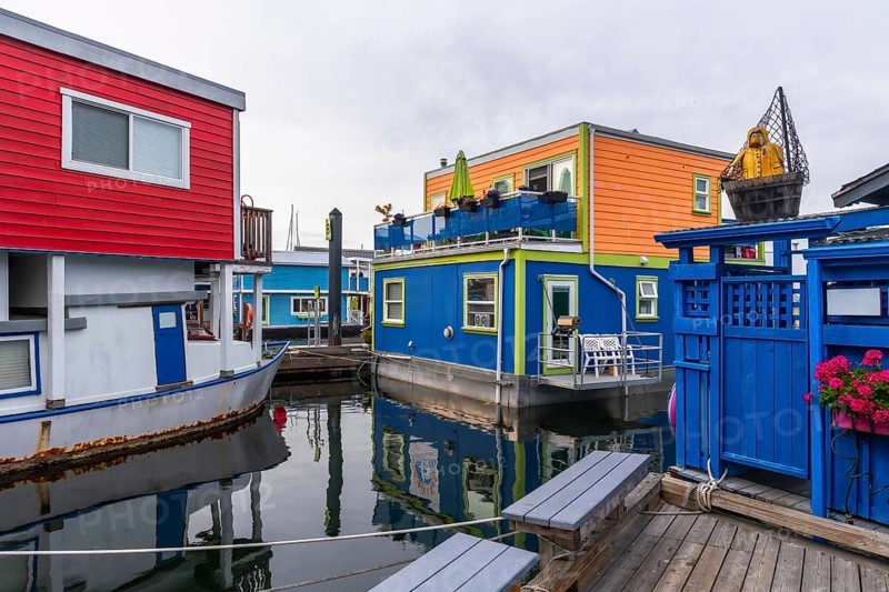 Fisherman's wharf park is showing its colorful floating homes in victoria, british columbia, a popular tourist destination with unique architecture and vibrant colors reflecting in the calm water