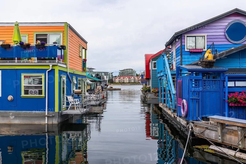 Fisherman's wharf park's vibrant floating homes create a picturesque scene, reflecting in the calm waters of victoria, british columbia, showcasing a unique and charming neighborhood