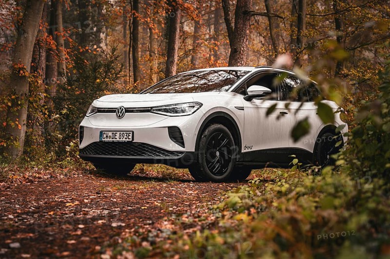 White car parked in forest surrounded by autumn leaves, VW ID4 electric car, Deer Carsharing, Calw, Germany