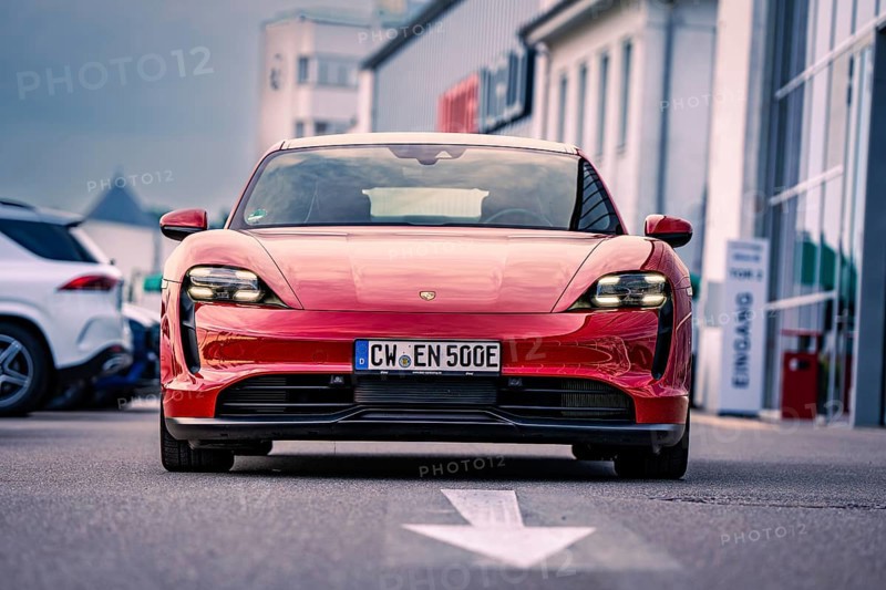 Red car of elegant design parked in an urban square, Porsche Taycan, Deer Carsharing. Calw, Germany