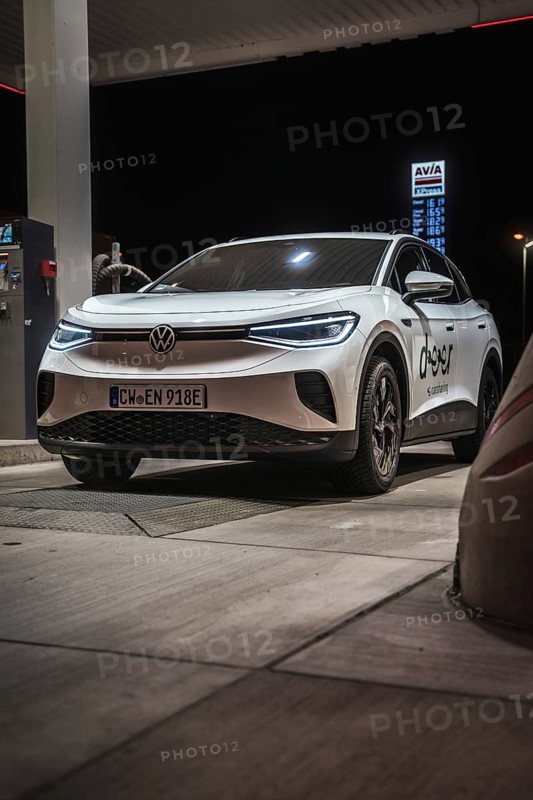 White car at a gas station at night, illuminated, VW ID4 electric car, Deer Carsharing, Calw, Germany