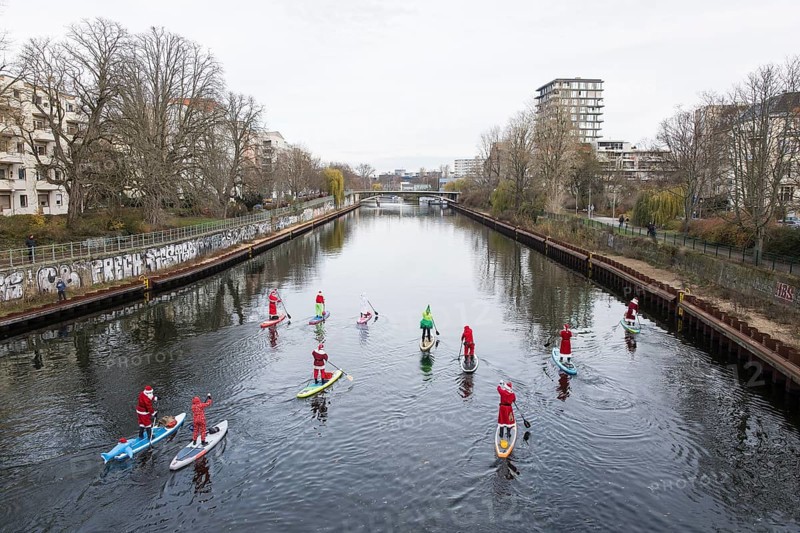 Water sports enthusiasts dressed up as Santa Claus ride SUPs on the Spree on the banks of the Hansa in Berlin on 30.11.2025