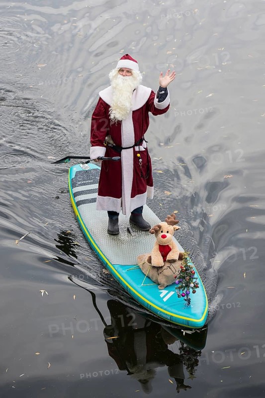 A water sports enthusiast dressed up as Santa Claus rides a SUP on the Spree in Berlin on 30.11.2025