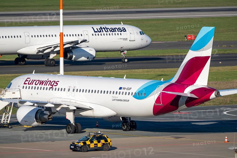 Lufthansa Airbus A321-200 on taxiway for takeoff, Eurowings Airbus parks outside position, Düsseldorf airport, DUS