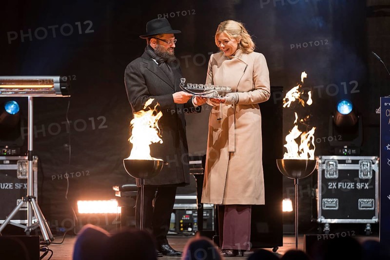 Julia Klöckner (President of the German Bundestag) receives a gift from Yehuda Teichtal (Rabbi of the Chabad-Lubavitch movement) at the lighting of lights to mark 20 years of Hanukkah in front of the Brandenburg Tor, Berlin, 17 December 2025