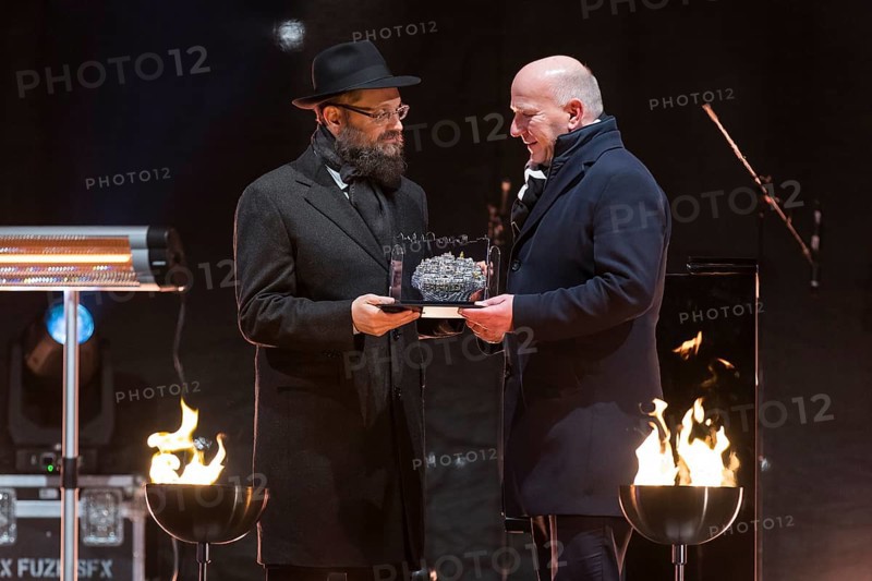 Kai Wegner (Governing Mayor of Berlin) receives a gift from Yehuda Teichtal (Rabbi of the Chabad-Lubavitch movement) at the lighting of the 20th anniversary of Hanukkah in front of the Brandenburg Tor, Berlin, 17 December 2025