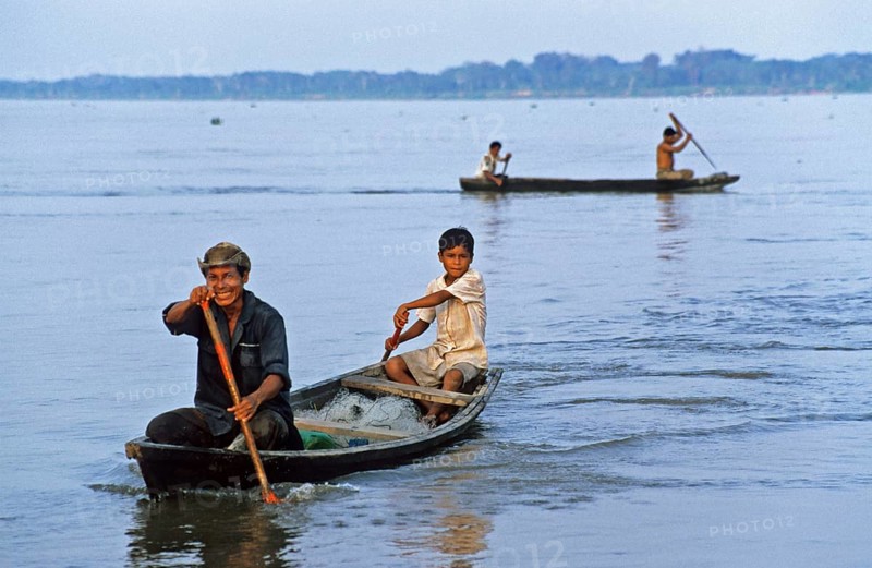 Father and son in a paddle boat on the Amazon near Iquitos, Peru, South America, September 1997, vintage, retro, old, historic