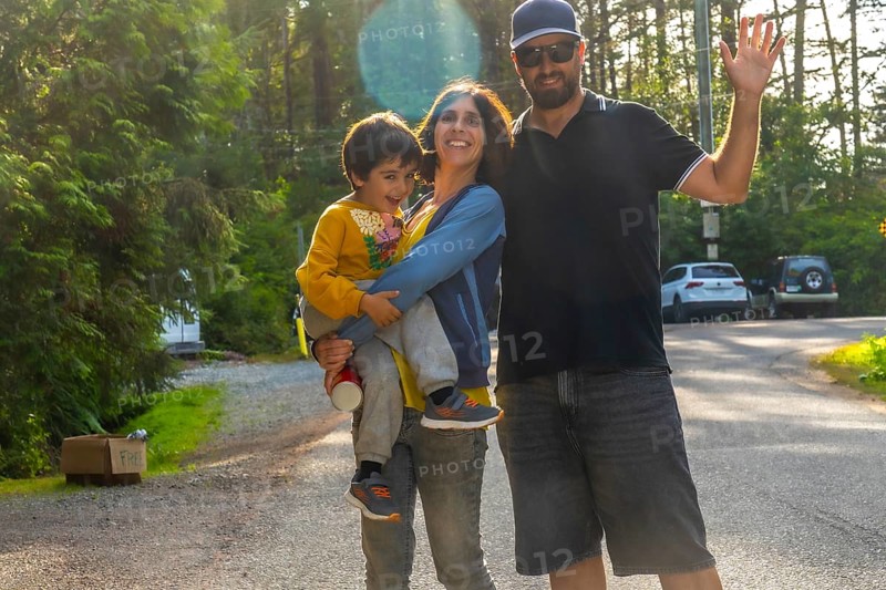 Happy family waving, enjoying their summer vacation in tofino, a popular tourist destination on vancouver island, british columbia, known for its beautiful beaches and lush rainforests