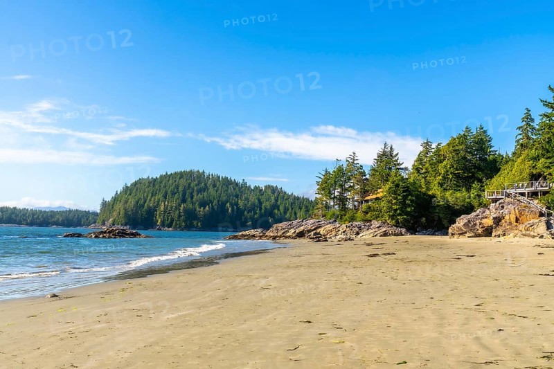 Golden sands meet crystal clear waters under a vibrant blue sky, creating a serene paradise at mackenzie beach, near tofino, on vancouver island, british columbia