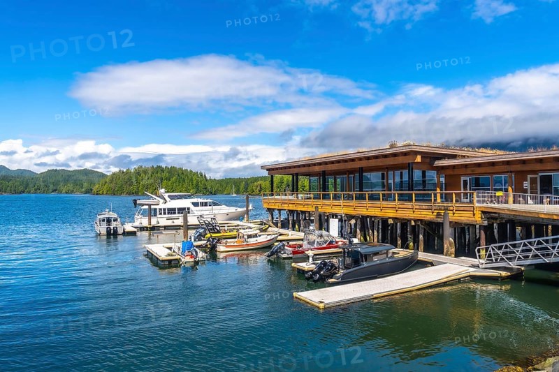 Modern architecture buildings overlooking clayoquot sound with boats moored at dock in tofino harbor on vancouver island, british columbia, canada, on a beautiful summer day