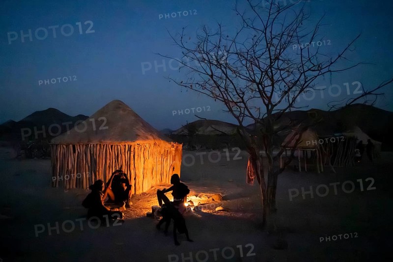 Himba at the campfire in the evening, night view, Himba huts, traditional Himba village in the savanna, Kaokoveld, Kunene, Namibia