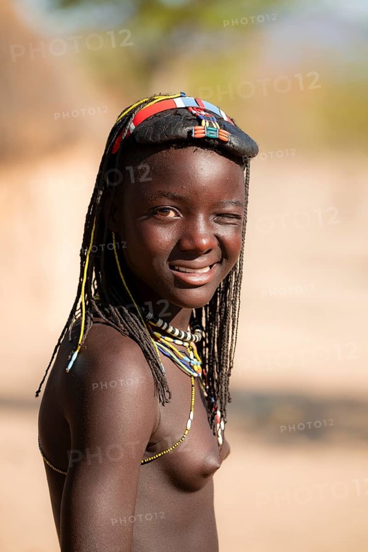 Portrait, brightly decorated girl winking, Hakaona tribe, also Havakona or Hakawona, near Opuwo, Kunene, Namibia