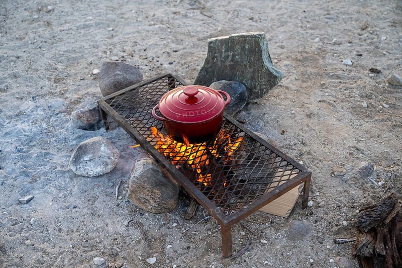 Single pot cooks on a campfire, preparing food while camping