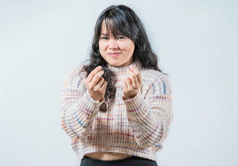 Cunning woman rubbing fingers showing money gesture isolated. Asian girl rubbing fingers asking for cash